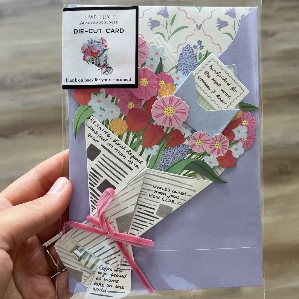 Hand holding the packaged Up With Paper x Anthropologie Mother's Day bouquet card
